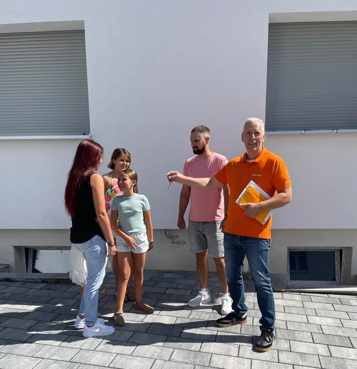 Rolf Lösch mit der Eigentümerfamilie vor ihrem sanierten Haus